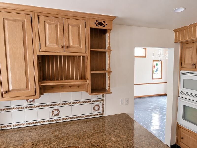 A dated kitchen with worn cabinets, photographed by the homeowner